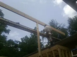 Carpenter setting a ridge beam over a new addition frame — Ice Dam Removal by Roofing Brothers in Ponte Vedra