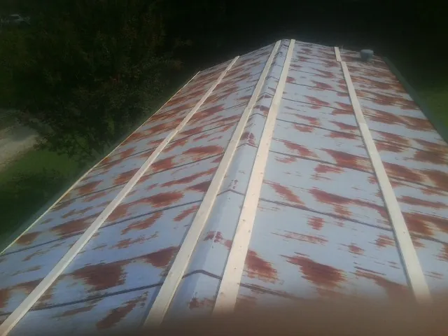 Rusted metal roof panels with new wood purlins before replacement — Storm Damage Roof Repair in Ponte Vedra by Roofing Brothers