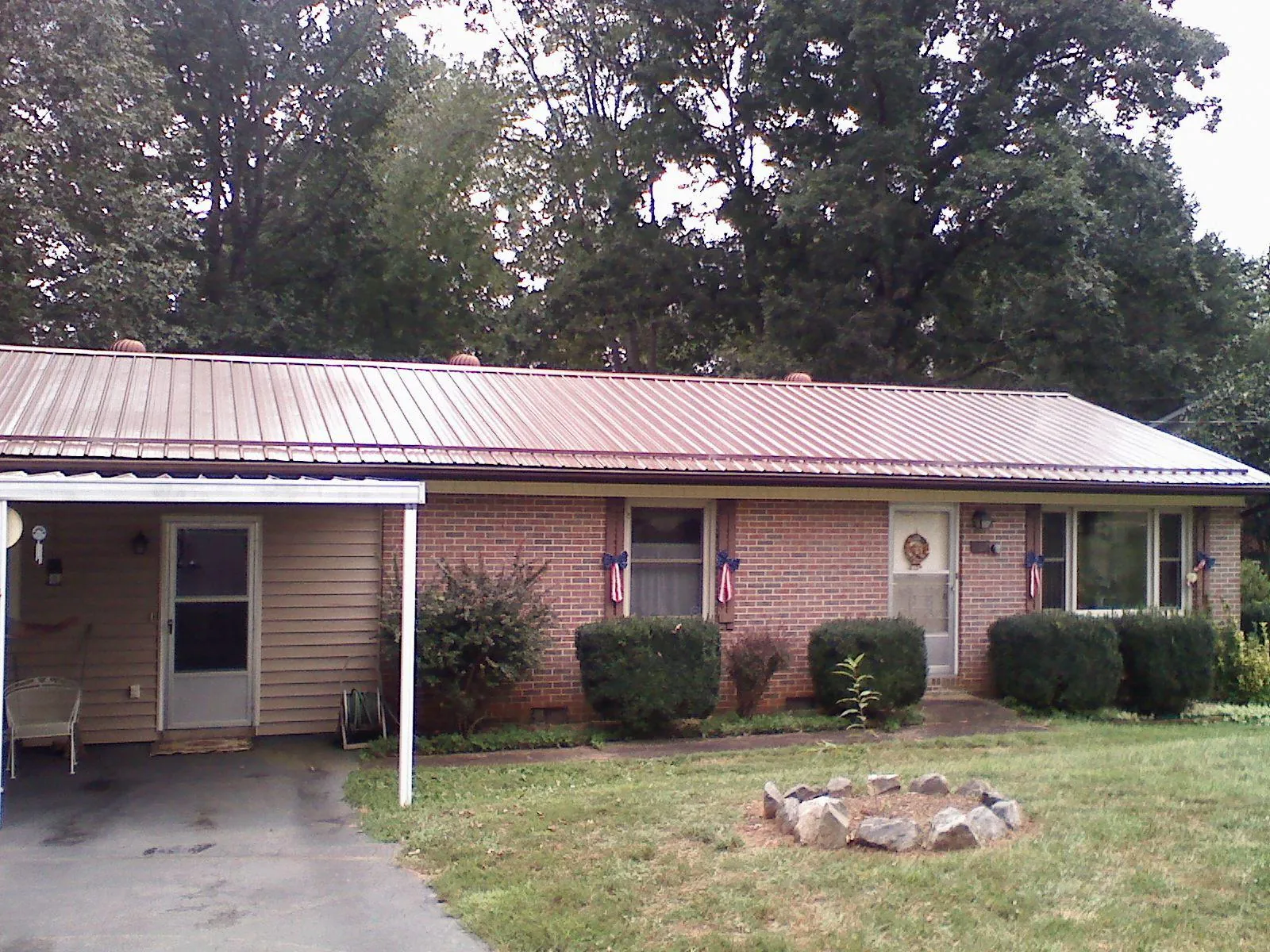 Bronze metal roof and carport on a brick ranch home — Roof Repair work by our crew in Ponte Vedra